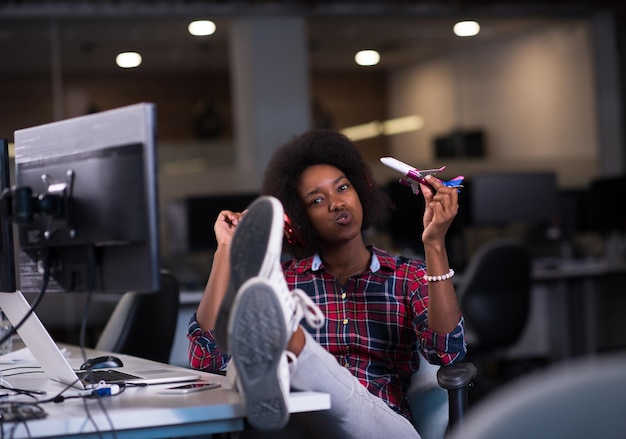 Foto retrato de uma jovem e bela mulher afro-americana de sucesso que gosta de passar um tempo alegre e de qualidade enquanto trabalha em um grande escritório moderno