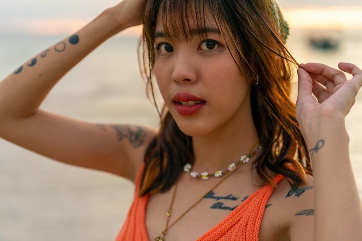 Foto retrato de uma jovem e bela mulher asiática caminhando na praia de uma ilha tropical no pôr-do-sol de verão uma mulher atraente relaxa-se e desfruta do estilo de vida ao ar livre em férias de praia e viagens de verão no mar