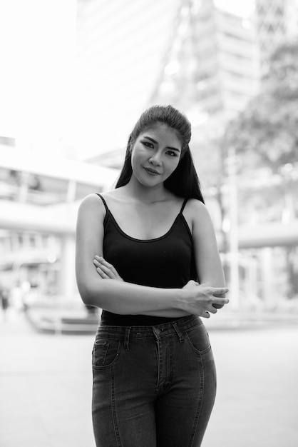 Retrato de uma jovem e bela mulher asiática explorando a cidade em preto e branco