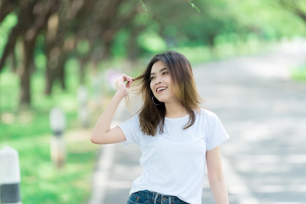 Retrato de uma jovem e bela mulher asiática feliz no parqueTailândia povoEstilo de vida da garota moderna