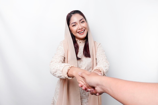 Retrato de uma jovem e bela mulher muçulmana asiática usando um lenço na cabeça gesticulando com a saudação de Eid Mubarak