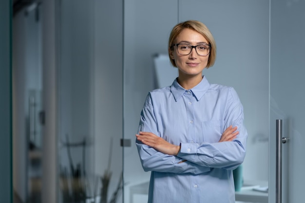 Retrato de uma jovem e bonita programadora arquiteta em pé no escritório com ela