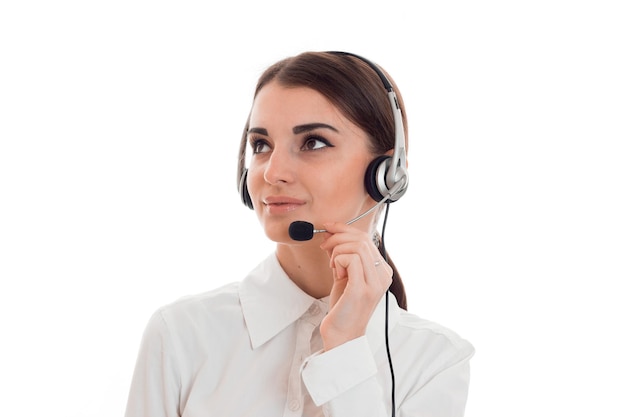 Retrato de uma jovem e linda garota trabalhadora de call center com fones de ouvido e microfone posando isolado em fundo branco