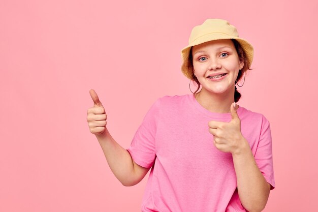 Retrato de uma jovem em estúdio de gestos de mão de camiseta rosa panamá bege