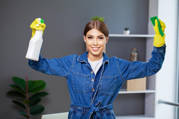 Retrato de uma jovem empregada feliz com material de limpeza