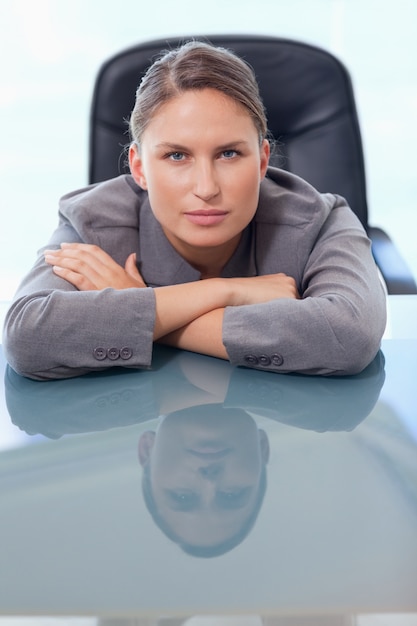 Retrato de uma jovem empresária apoiada em sua mesa