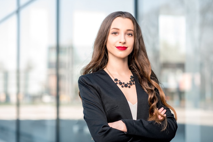 Foto retrato de uma jovem empresária caucasiana em pé ao ar livre perto da fachada moderna
