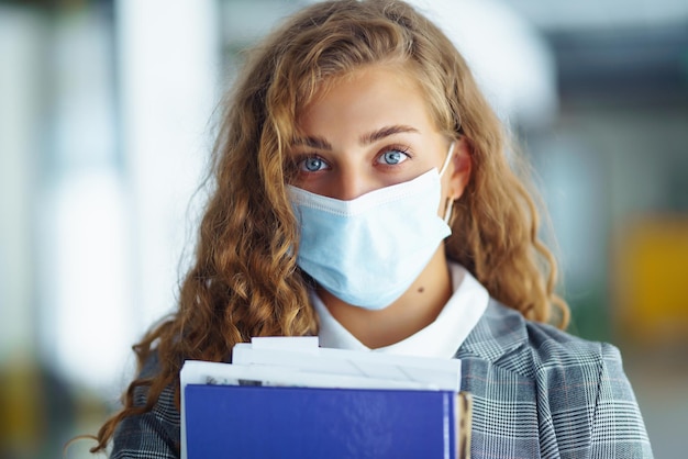 Retrato de uma jovem empresária com máscara facial protetora no escritório Mulher Empreendedora COVID 19