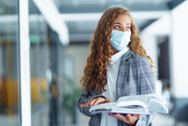 Retrato de uma jovem empresária com máscara facial protetora no escritório Mulher Empreendedora COVID 19