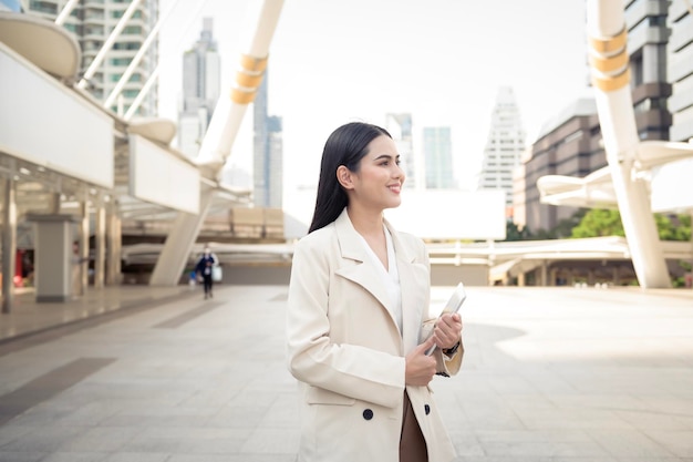 Retrato de uma jovem empresária linda usando tablet na cidade moderna