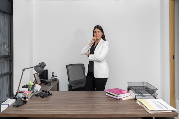 Retrato de uma jovem empresária realizada com os braços cruzados em seu escritório com espaço de cópia para texto