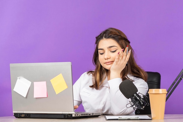 Retrato de uma jovem empresária sentada atrás da mesa e olhando para baixo Foto de alta qualidade