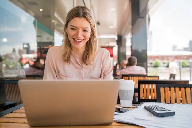 Retrato de uma jovem empresária trabalhando em seu laptop em uma cafeteria