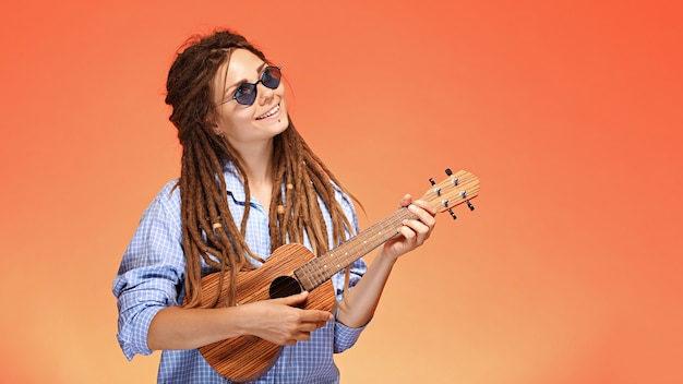 Retrato de uma jovem engraçada tocando cavaquinho