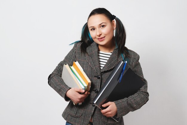 Retrato de uma jovem estudante confiante segurando livros e pastas
