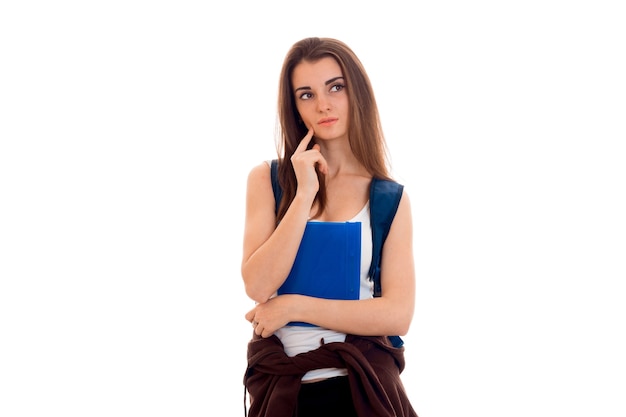 Foto retrato de uma jovem estudante pensativa com mochila azul e pastas para cadernos isolados no fundo branco