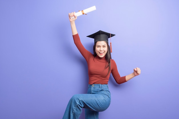 Foto retrato de uma jovem estudante universitária com chapéu de formatura violeta
