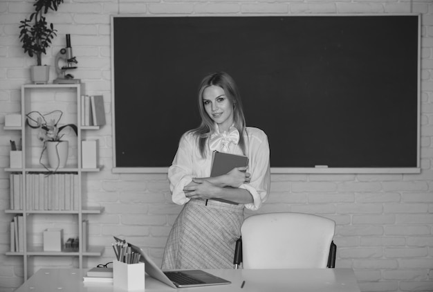 Foto retrato de uma jovem estudante universitária estudando em sala de aula na aula com fundo de quadro-negro