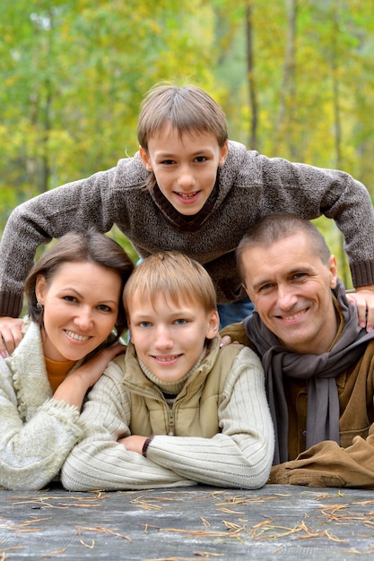 Retrato de uma jovem família feliz descansando no parque outono