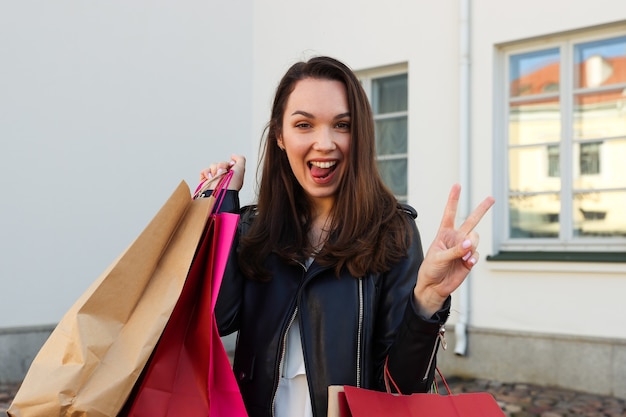 Retrato de uma jovem feliz com um monte de pacotes depois das compras