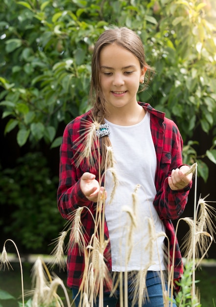 Retrato de uma jovem feliz em um campo de trigo em um dia de sol