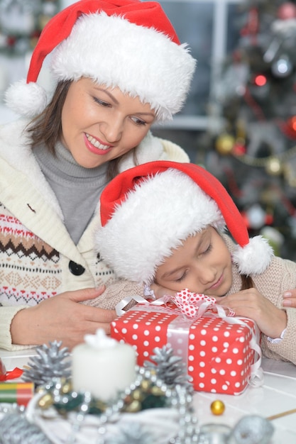 Retrato de uma jovem feliz mãe e filha se preparando para o Natal