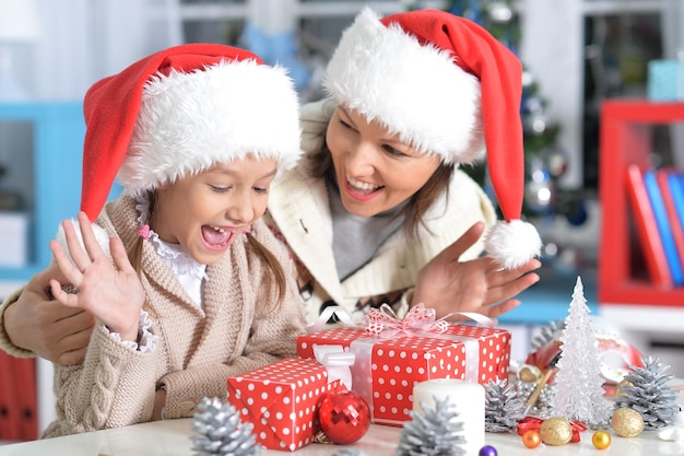 Retrato de uma jovem feliz mãe e filha se preparando para o Natal