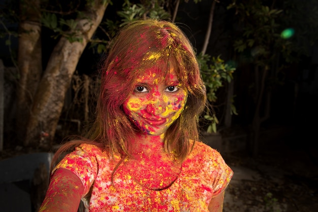 Retrato de uma jovem feliz no festival de cores Holi. Garota posando e comemorando o festival das cores.