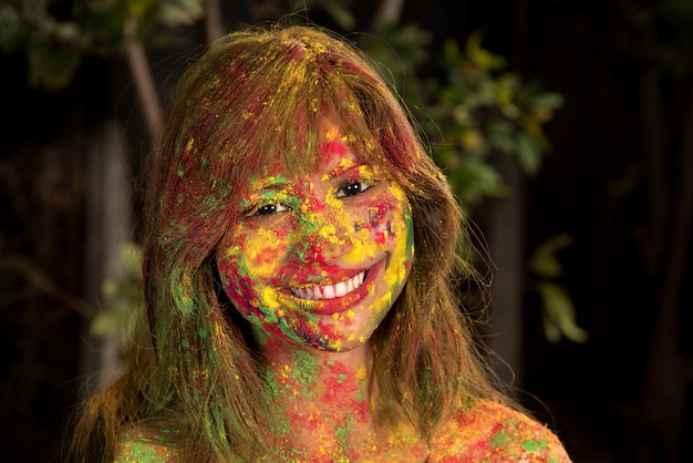Retrato de uma jovem feliz no festival de cores Holi. Garota posando e comemorando o festival das cores.