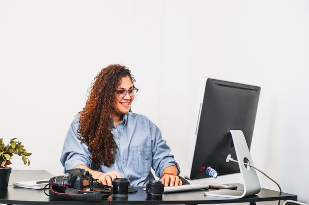 Retrato de uma jovem fotógrafa trabalhando em sua mesa