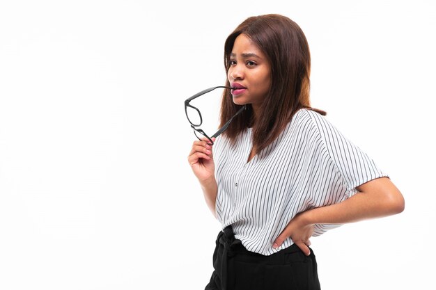 Foto retrato de uma jovem garota afro-americana atraente possing com óculos no fundo