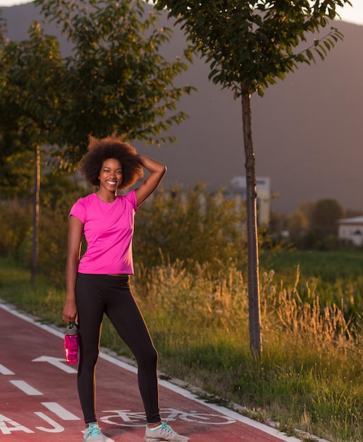 retrato de uma jovem garota afro-americana para correr linda noite de verão nas ruas da cidade