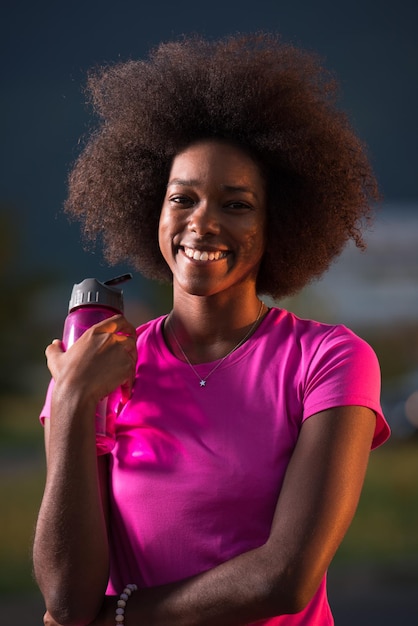 retrato de uma jovem garota afro-americana para correr linda noite de verão nas ruas da cidade