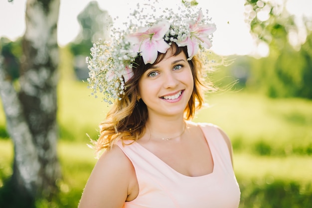 Retrato de uma jovem garota caucasiana com uma coroa de flores na cabeça