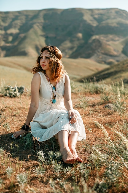 Retrato de uma jovem garota em um vestido branco translúcido no estilo boho ou hippie