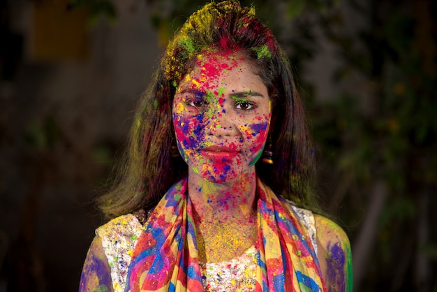 Retrato de uma jovem garota feliz com um rosto colorido por ocasião do festival de holi cor.