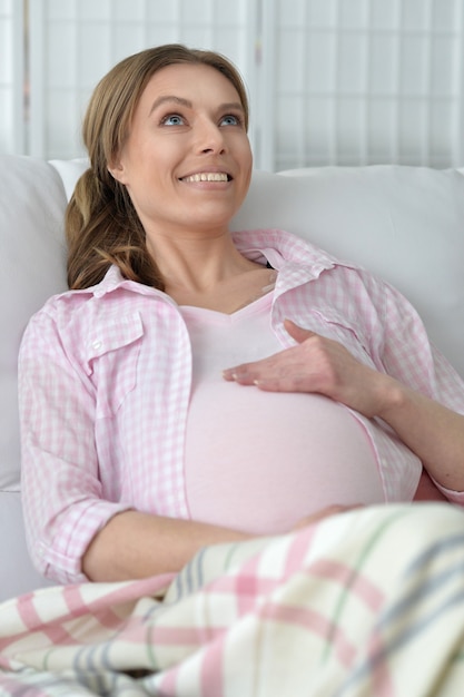 Retrato de uma jovem grávida segurando a barriga