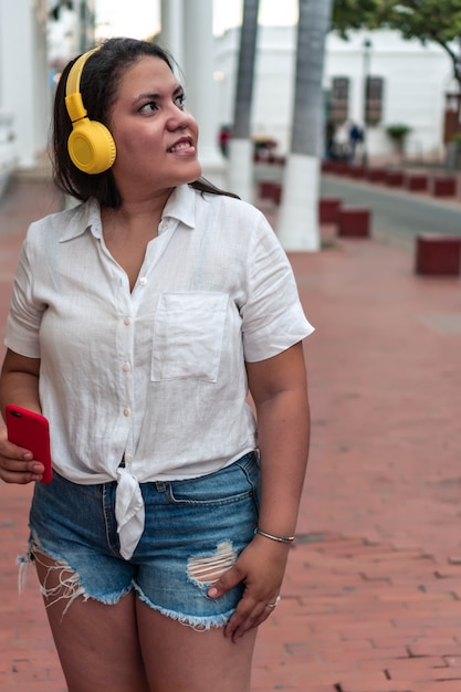 Retrato de uma jovem hispânica ouvindo música ao ar livre
