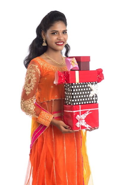 Retrato de uma jovem indiana feliz e sorridente segurando caixas de presente em branco