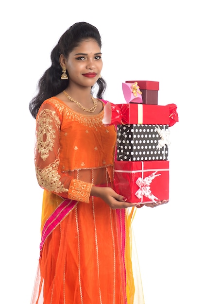 Retrato de uma jovem indiana feliz e sorridente segurando caixas de presente em branco