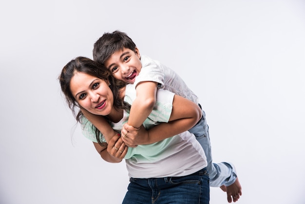 Retrato de uma jovem indiana mãe e filho contra um fundo branco, olhando para a câmera