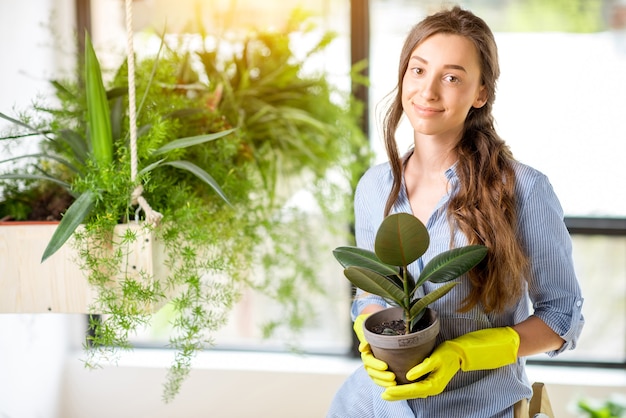 Retrato de uma jovem jardineira segurando um vaso de flores no laranjal