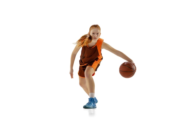 Retrato de uma jovem jogadora de basquete treinando bola de drible isolada sobre fundo branco