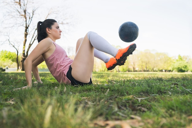 Retrato de uma jovem jogadora de futebol treinando e praticando habilidades no campo de futebol. Conceito de esportes.