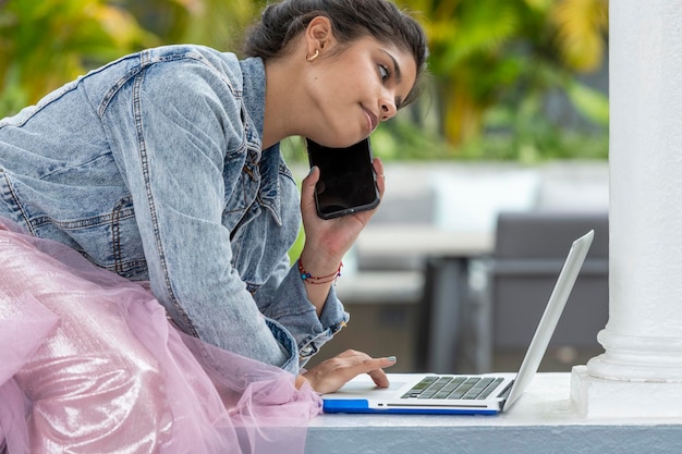 Retrato de uma jovem latina usando laptop ao ar livre Foto Premium