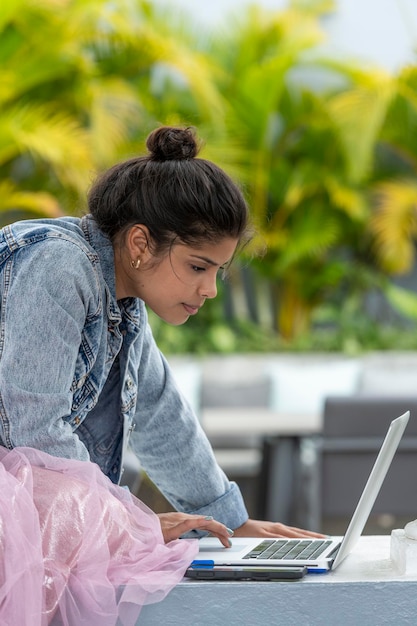 Retrato de uma jovem latina usando laptop ao ar livre Foto Premium