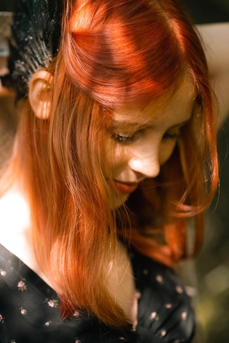 Foto retrato de uma jovem linda com cabelo ruivo na natureza com asas de pássaro na cabeça