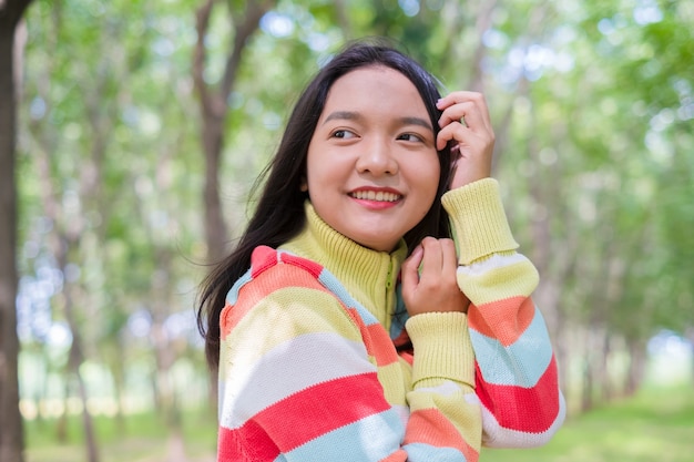 Retrato de uma jovem linda com suéter no fundo da natureza