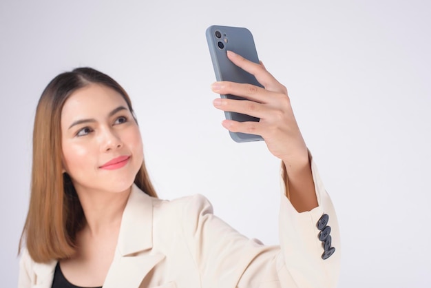 Retrato de uma jovem linda de terno usando telefone inteligente sobre fundo branco