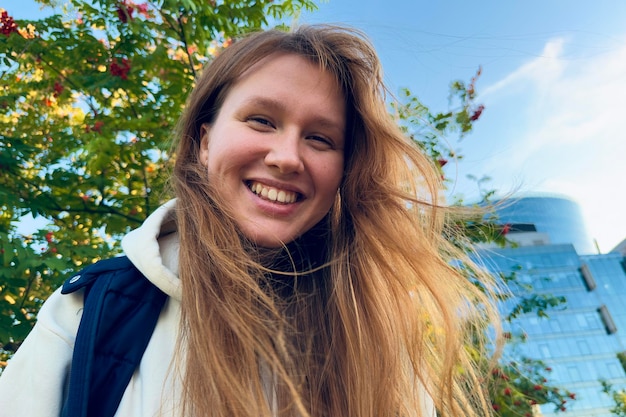 Retrato de uma jovem linda e feliz andando ao ar livre no verão ou no parque dourado do outono